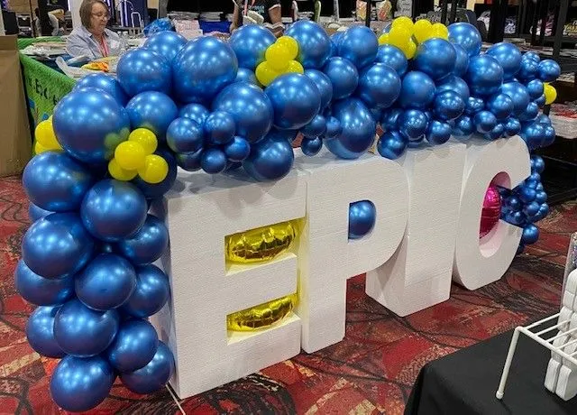 statue of the word EPIC with blue balloons around it